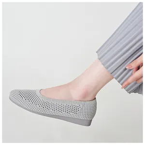 Primo piano di scarpe in maglia grigio chiaro traspiranti con motivo traforato