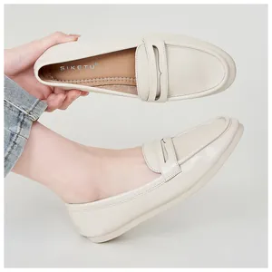 Detail view of beige leather penny loafers with soft matte finish and rounded toe design
