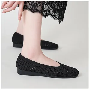 Dettaglio delle scarpe con zeppa in maglia nera traspirante con motivo traforato