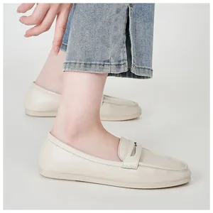Detail shot of off-white leather loafers paired with denim jeans for daily casual wear