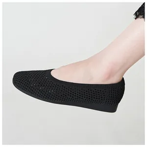 Dettaglio delle scarpe con zeppa in maglia nera traspirante e suola piatta comoda indossate