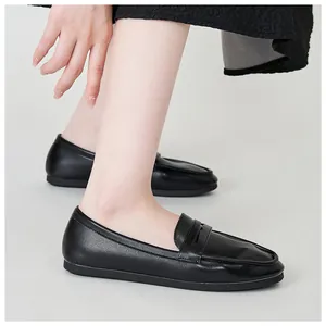 Side view of matte black leather loafers for women with minimalist classic strap detail