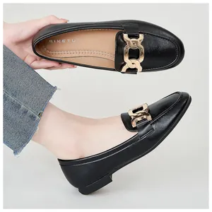 Detail view of black leather loafers with gold chain accent and soft inner lining