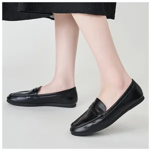 Close-up of classic black leather loafers showing smooth texture and saddle strap detail