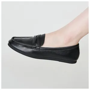 Detail shot of black leather loafers showing soft texture and premium stitching on feet
