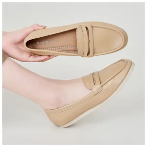 Close-up of soft beige leather penny loafers for women featuring flexible flat soles