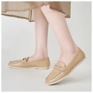 Detail view of beige leather penny loafers featuring a classic rounded toe and sleek side profile