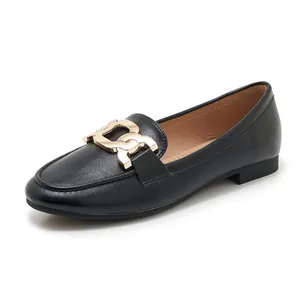 Close-up of women's black loafers featuring a stylish gold metal chain buckle detail
