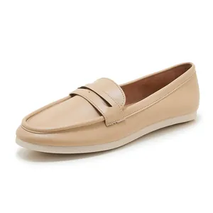 Close-up of beige leather loafers featuring white rubber soles and fine stitching detail