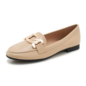 Detailed macro view of beige leather loafer with chunky gold chain buckle and stitching