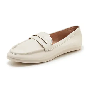Close-up of cream leather loafers showing round toe and classic strap detail