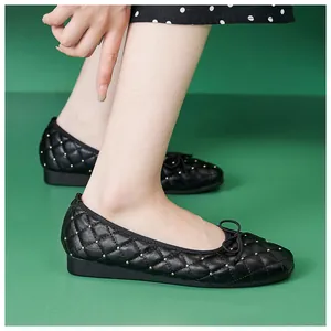 Detail schwarzer gesteppter Ballerinas mit Goldnieten und kleiner Schleife für Damen