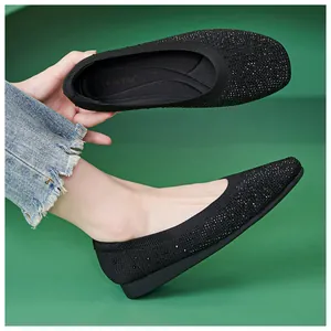 Detail of black knit ballerina flat showing sparkling rhinestone finish and brand insole