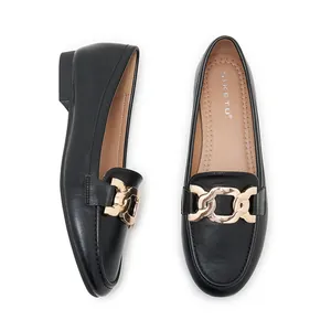 Detail view of black leather loafers featuring gold chain hardware and comfort insoles