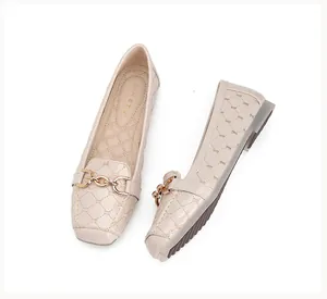 Detail van beige gewatteerde platte schoenen met glanzende vierkante neus en goud