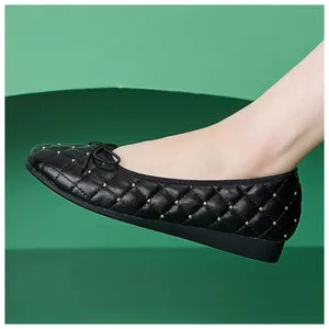 Detail von schwarzen gesteppten Ballerinas mit Goldperlen-Akzenten und Schleifen-Deko