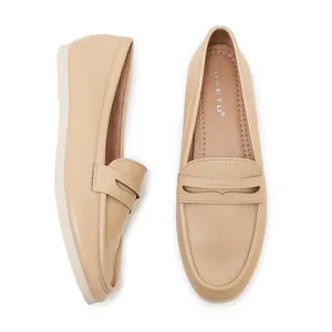 Detail view of beige loafers featuring soft leather texture and branded inner sole