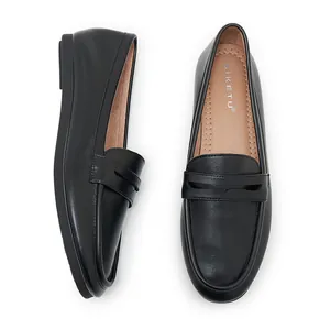 Detail view of black leather loafers showing classic strap and soft tan inner lining