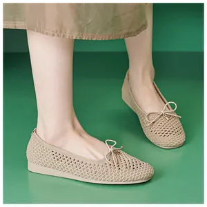 Detail of apricot knit flat shoes with bow accent and breathable mesh on model's feet