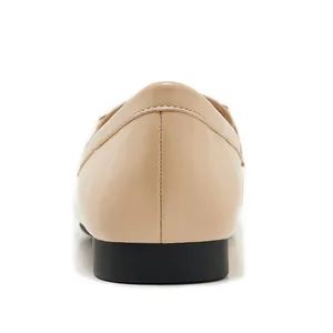 Detailed close-up of vertical stitching and heel structure on beige leather loafer