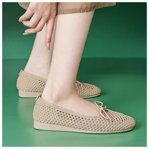 Detail of beige hollow-out flats with bow accent and breathable mesh texture on feet