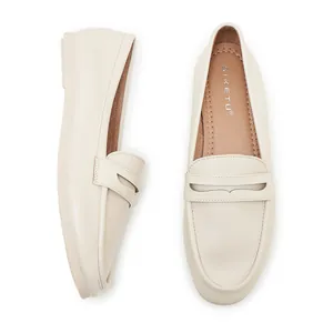 Detailed side and top view of cream leather loafers with signature insole and stitching