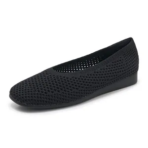 Dettaglio del tessuto fly-knit nero traspirante sulle scarpe con zeppa da donna