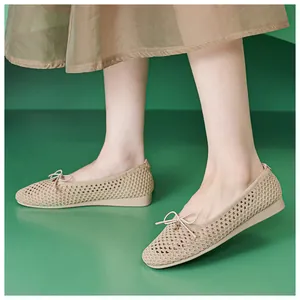 Close-up of beige hollow mesh ballet flats with bow detail and breathable texture