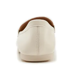 Detailed back view showing double stitching and soft leather texture of cream loafers