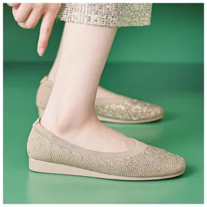 Detail of beige knitted ballet flats featuring sparkling rhinestones and elastic collar