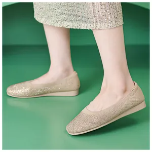 Close-up of beige knit ballet flats with shimmering rhinestones and soft pointed toe