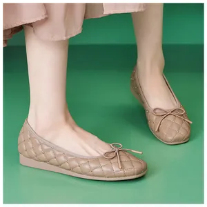 Detail von nudefarbenen gesteppten Leder-Ballerinas mit Goldnieten und Schleife