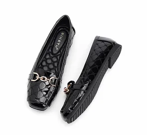 Detailopname van zwarte laklederen loafers met gouden kettinggesp en antislipzool