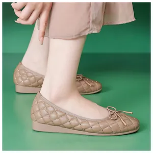 Nahaufnahme gesteppte Leder-Ballerinas mit Goldnieten und schicker Schleifen-Verzierung