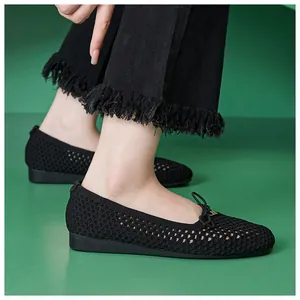 Detailed view of black breathable mesh flat shoes with bow tie and hollow knit texture