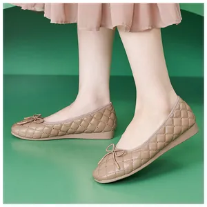 Nahaufnahme der gesteppten Ballerinas in Apricot mit Metallnieten und eleganter Schleife