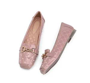 Detailweergave van de doorgestikte laklederen schoenen met een gouden kettingsluiting