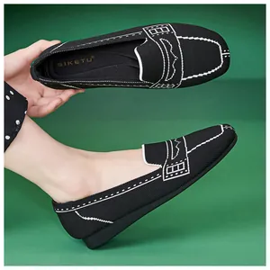 Detail von schwarzen Strick-Loafers mit weißen Nähten und flexiblem Slip-on-Design