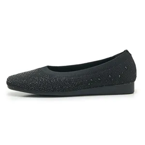 Detail shot of black knitted flat shoes featuring sparkling rhinestone embellishments