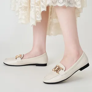 Elegant beige leather loafers for women with decorative gold buckle and black soles