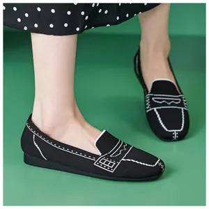 Leichte schwarze Strick-Loafer für Damen kombiniert mit einem gepunkteten Rock