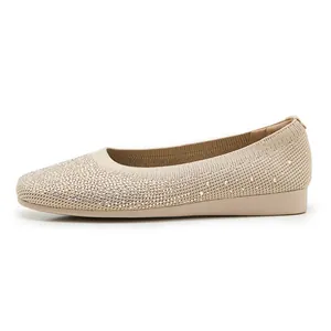 Close-up of beige knitted flat shoes with rhinestone detailing and breathable fabric