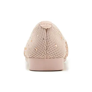 Detail of mauve knit flat shoes with rhinestone embellishments on soft fabric texture
