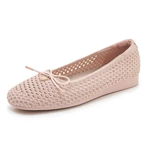 Close-up of pink mesh ballet flat with bow detail and golden buckle accents
