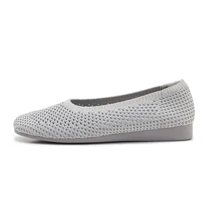 Dettaglio della tomaia in maglia grigia traspirante su scarpe con zeppa confortevoli