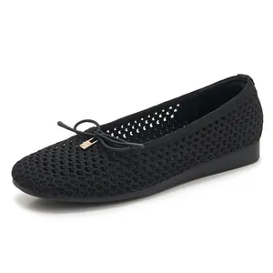 Detail view of black knitted flat shoe with hollow mesh and bowknot metal charm