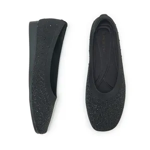 Detailed close-up of black knit ballet flats with rhinestone embellishments and square toe