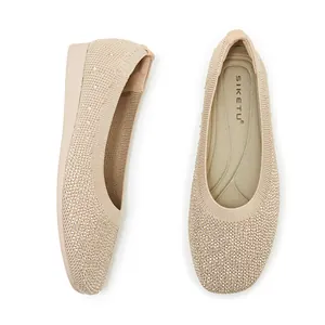 Detailed view of beige flyknit flats with sparkling rhinestones and a low-wedge heel