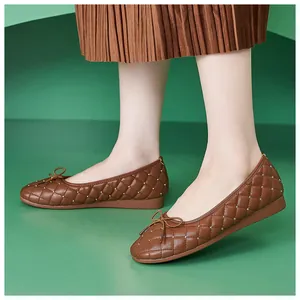 Detail brauner gesteppter Ballerinas mit Silbernieten und eleganter Schleifendetail