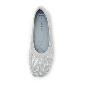 Macro view of silver fly-knit ballet flats with sparkling rhinestones and round toe